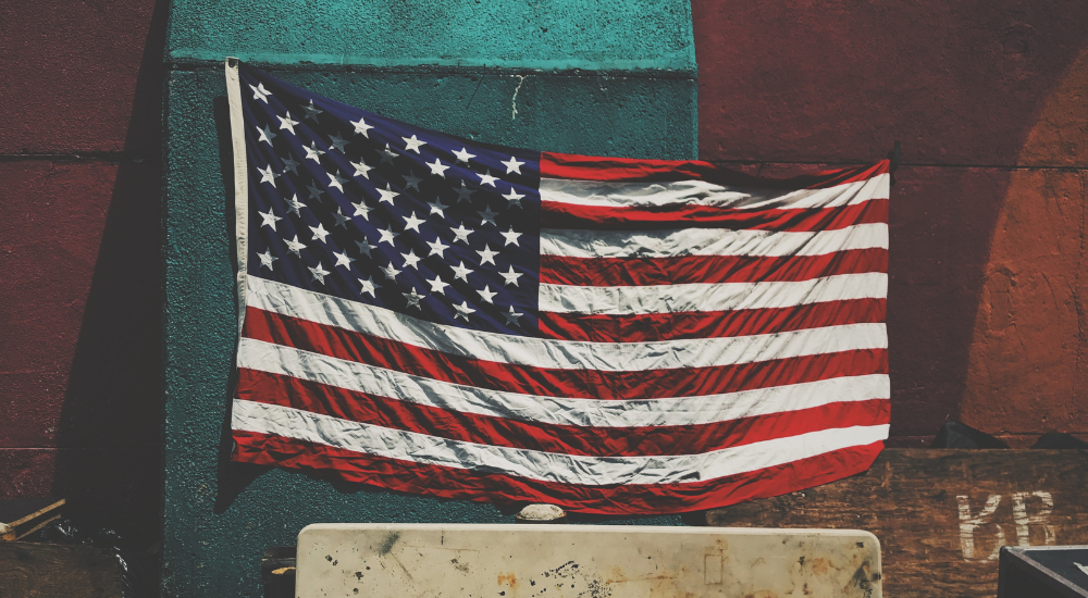 american flag in front of turquoise and brown structure